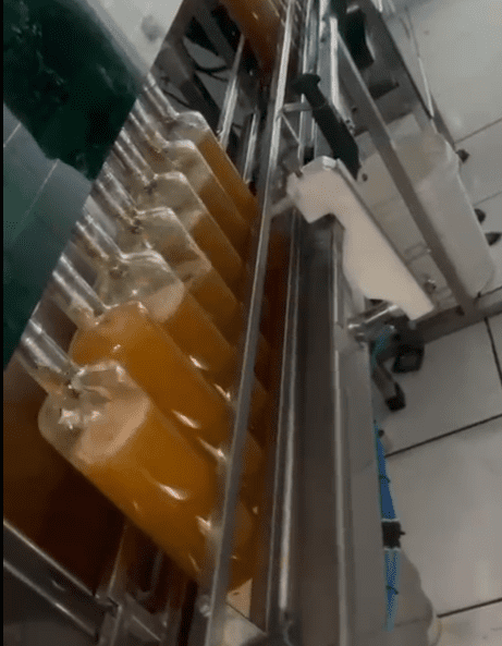 Máquina enchendo as garrafas de Santo Mel em nosso processo